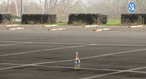 Leere Sektflasche auf einem leeren Parkplatz, 1. Januar morgens