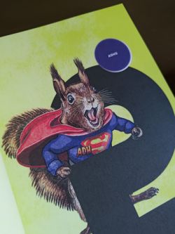 Eichhörnchen mit Superman-Shirt, vor dem S für Superman steht ADH